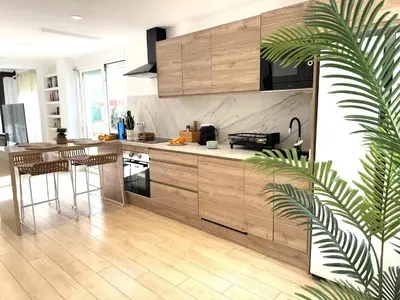 a kitchen with wooden cabinets and a potted plant at Casa Del Mar, piscina privada frente al mar in Cullera
