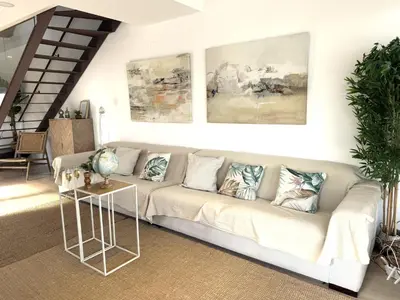a living room with a couch and paintings on the wall at Casa Del Mar, piscina privada frente al mar in Cullera