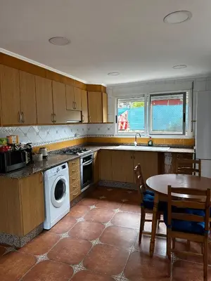 a kitchen with a table and a washing machine at Villa Rosa Rasero in Serratella