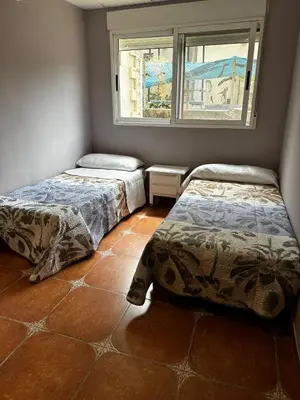 a room with two beds and a window at Villa Rosa Rasero in Serratella