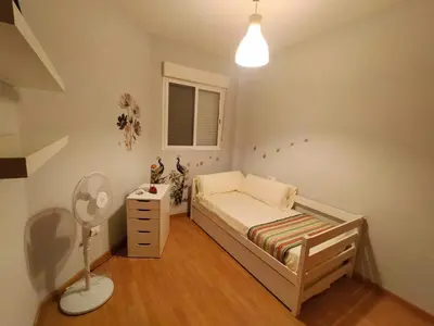 a small bedroom with a bed and a lamp at Luminoso piso en edificio de canet de berenguer in Canet de Berenguer