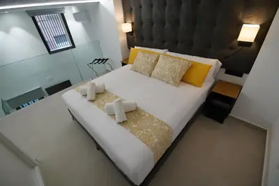 a bedroom with a large white bed with yellow pillows at BET Apartments - Suites Puerto Valencia in Valencia