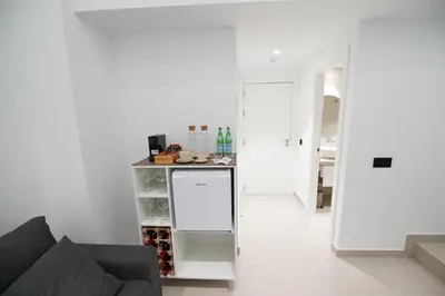 a living room with a couch and a counter with wine bottles at BET Apartments - Suites Puerto Valencia in Valencia
