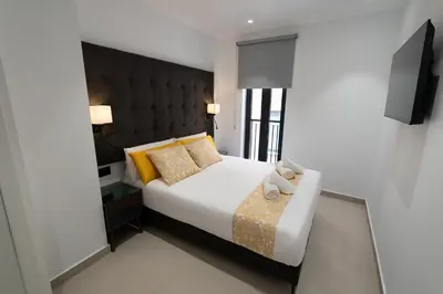 a bedroom with a large bed with a black headboard at BET Apartments - Suites Puerto Valencia in Valencia