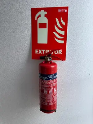 a red fire extinguisher is hanging on a wall at DJcumar Apartamento en Cullera comodo y bien ubicado in Cullera