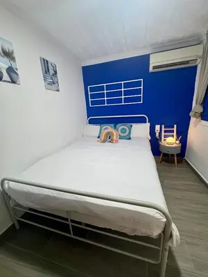 a bed in a room with a blue wall at DJcumar Apartamento en Cullera comodo y bien ubicado in Cullera