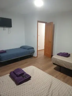 a room with two beds and a door with a mirror at Cantarranas in Requena