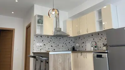 a kitchen with white cabinets and a stainless steel refrigerator at Del Mar 1C - New Beach First floor One bed flat in Puerto de Sagunto