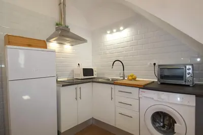 a kitchen with a washer and a sink and a microwave at Casa típica del Cabanyal in Valencia