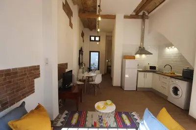 a kitchen and a living room with a table at Casa típica del Cabanyal in Valencia