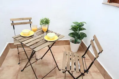 a table with two glasses of orange juice and two chairs at Casa típica del Cabanyal in Valencia