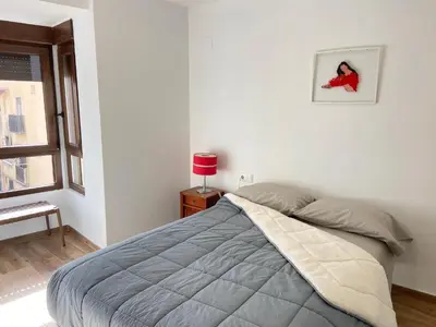 a bed in a white room with a window at Apartamento artístico en el centro de Segorbe in Segorbe