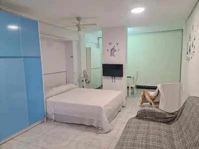 a bedroom with a bed and a tv and a couch at Edificio El Sol in Cullera