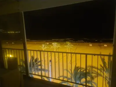 a view of a balcony with palm trees at night at Edificio El Sol in Cullera