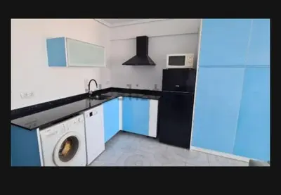 a kitchen with a washing machine and a refrigerator at Edificio El Sol in Cullera