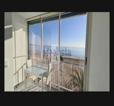 a balcony with a table and a view of the beach at Edificio El Sol in Cullera