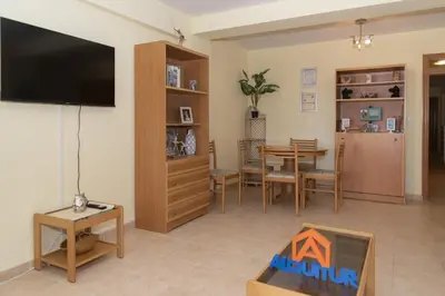 a living room with a television and a dining room at Amador, 4-J in Cullera