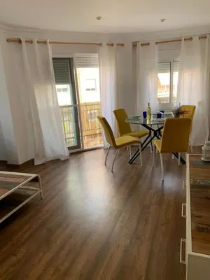 a dining room with a table and yellow chairs at Sueca 1 in Sueca