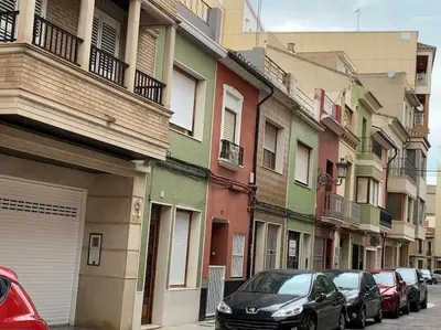 a row of buildings on a street with parked cars at Sueca 1 in Sueca