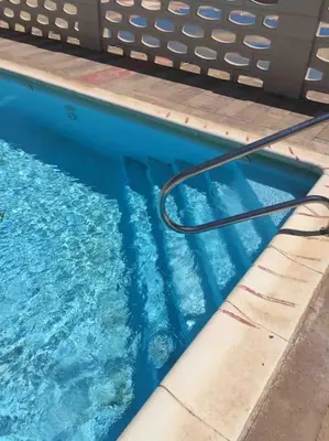 a swimming pool with a hose in the water at Alquiler de temporada Canet Playa - en primera linea in Canet de Berenguer
