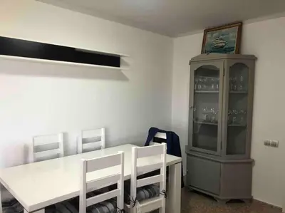 a dining room with a table and a china cabinet at Alquiler de temporada Canet Playa - en primera linea in Canet de Berenguer