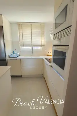 a white kitchen with a sink and a microwave at BEACH VALENCIA LUXURY B7-23 Apartment with terrace and sea views in Valencia