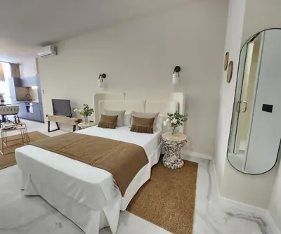 a white bedroom with a large bed and a mirror at MD Pare Presentat in Valencia