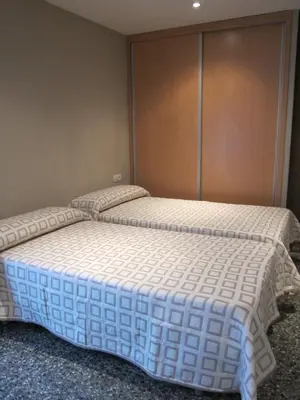 two twin beds in a room with a wall at Apartamentos Abastos in Valencia
