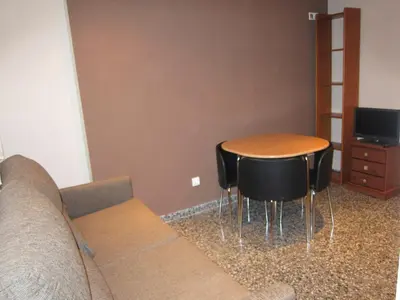 a living room with a couch and a table and chairs at Apartamentos Abastos in Valencia