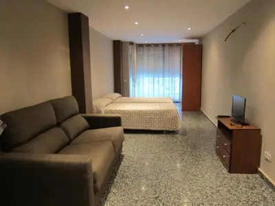 a living room with a couch and a bed at Apartamentos Abastos in Valencia