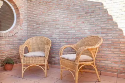 two wicker chairs sitting next to a brick wall at Casa en Valencia, piscina, cerca de golf, playas, moto Gp in Valencia