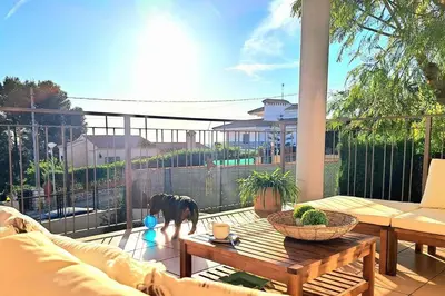 a dog standing on a patio with a table at Casa en Valencia, piscina, cerca de golf, playas, moto Gp in Valencia
