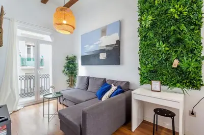 a living room with a couch and a green wall at RUZAFA COOL LOFT in Valencia