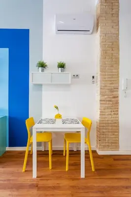 a dining room with a white table and yellow chairs at RUZAFA COOL LOFT in Valencia