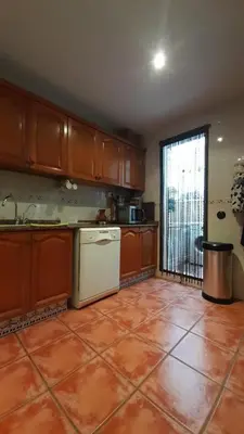 a kitchen with wooden cabinets and an orange tile floor at Zanzibar Beach Puzol relax en la playa cerca de Sagunto y Valencia in Puzol