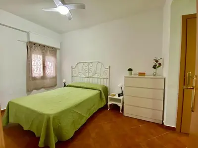 a bedroom with a green bed and a dresser at Sol y Mar in Puebla de Farnals