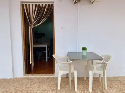 a table and chairs in a room with a door at Sol y Mar in Puebla de Farnals