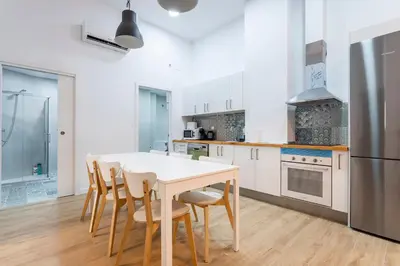 a kitchen with a table and chairs and a refrigerator at 10 pax, AC, Wifi gratis, Ciudad Artes y Ciencias in Valencia