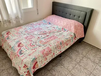 a bed with a quilt on it in a bedroom at 3-bedroom apartment with terrace on ground floor in Moncófar