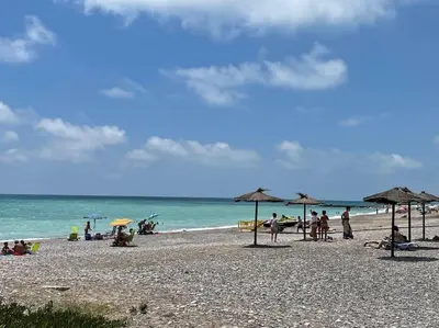a group of people sitting on a beach with umbrellas at 3-bedroom apartment with terrace on ground floor in Moncófar