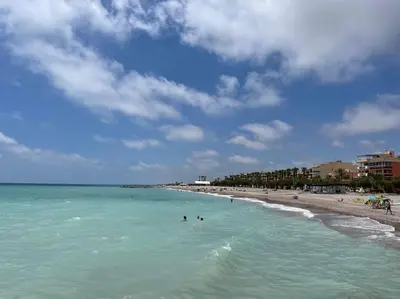 a beach with people swimming in the water at 3-bedroom apartment with terrace on ground floor in Moncófar