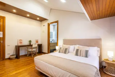 a bedroom with a large bed and a desk at Dolce Vita B&B - Only Adults in Valencia