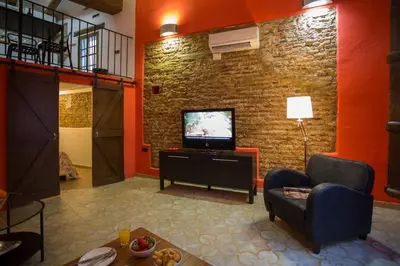 a living room with a tv and a brick wall at Next to Central Market, Cathedral and Town Hall in Valencia