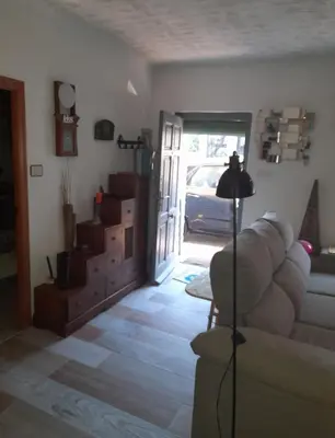 a living room with a couch and a door to a garage at ROSA in Llaurí
