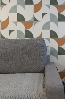 a couch in front of a wall with geometric wallpaper at Victoria Inn Apartment in Valencia