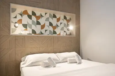 a bedroom with a white bed with two towels at Victoria Inn Apartment in Valencia
