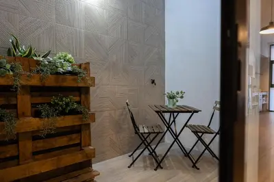a table and chairs in a room with a wall at Victoria Inn Apartment in Valencia