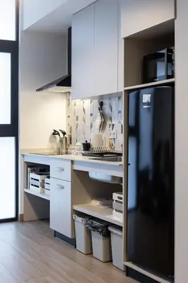 a kitchen with white cabinets and a black refrigerator at Victoria Inn Apartment in Valencia