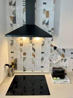 a kitchen with a stove and a black hood at Victoria Inn Apartment in Valencia