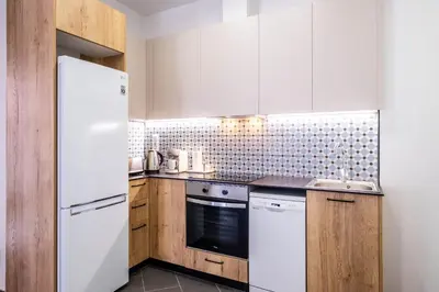 a kitchen with a white refrigerator and wooden cabinets at New and Modern Apartment with Comfy Beds in Valencia